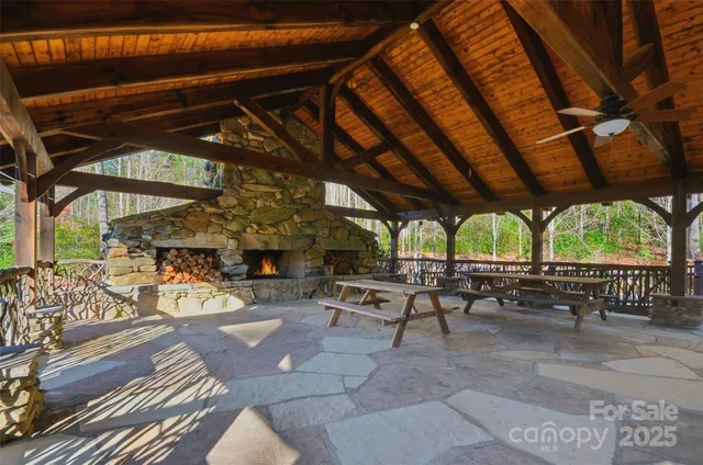 a view of a patio with a table and chairs under an umbrella with a barbeque