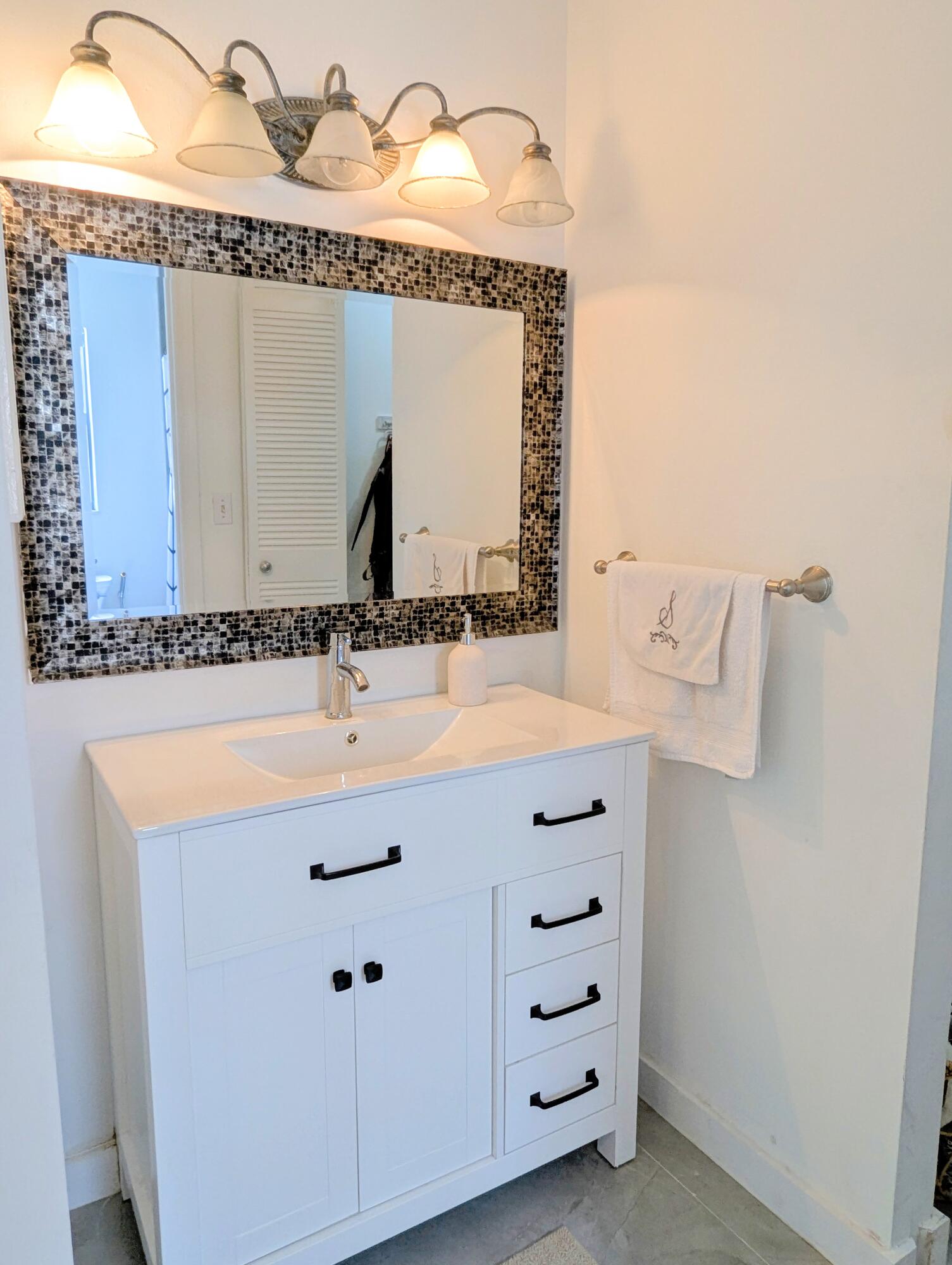 3130 Millwood Terrace, Unit 2160 Boca Raton, FL 33431 - Photo 13 of 34 a bathroom with a sink and a mirror