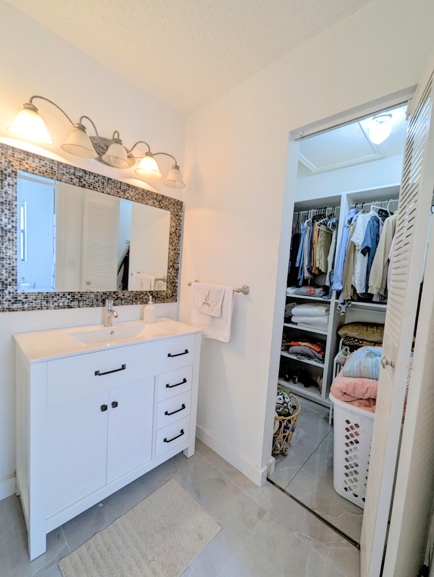 3130 Millwood Terrace, Unit 2160 Boca Raton, FL 33431 - Photo 14 of 34 a bathroom with a double vanity sink and mirror
