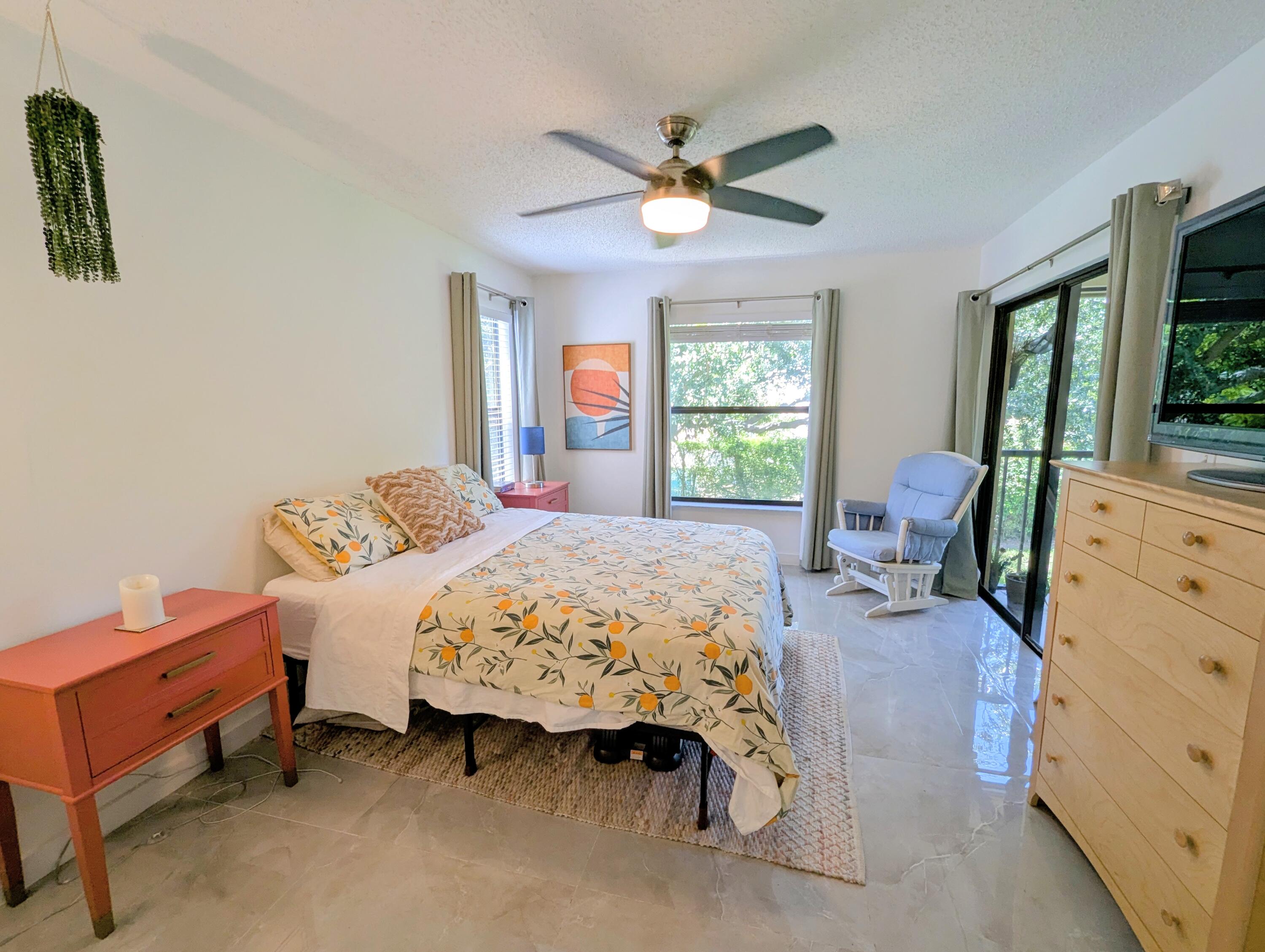 3130 Millwood Terrace, Unit 2160 Boca Raton, FL 33431 - Photo 16 of 34 a bedroom with a bed and a dresser next to a window