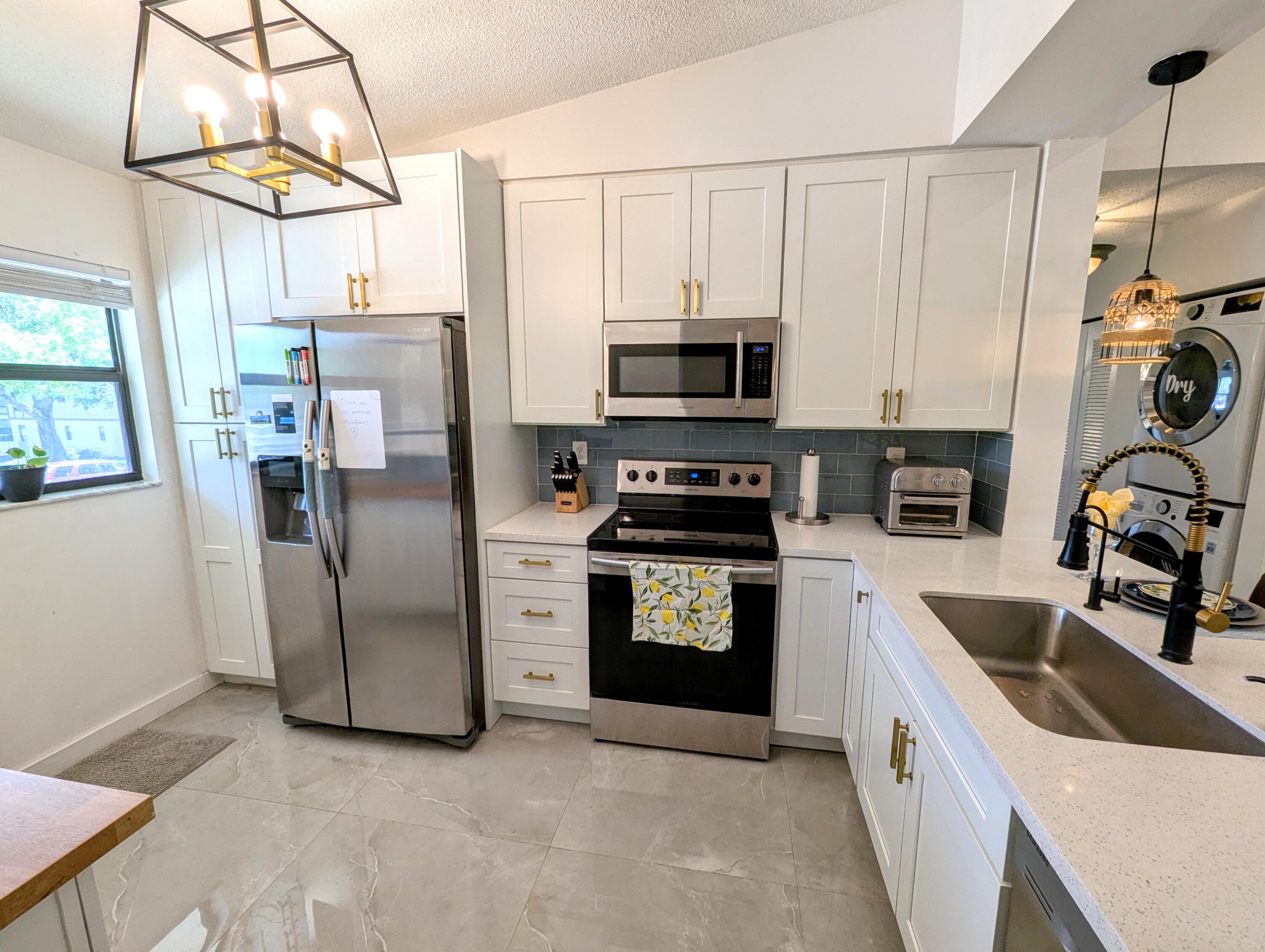 3130 Millwood Terrace, Unit 2160 Boca Raton, FL 33431 - Photo 4 of 34 a kitchen with stainless steel appliances a refrigerator sink and microwave