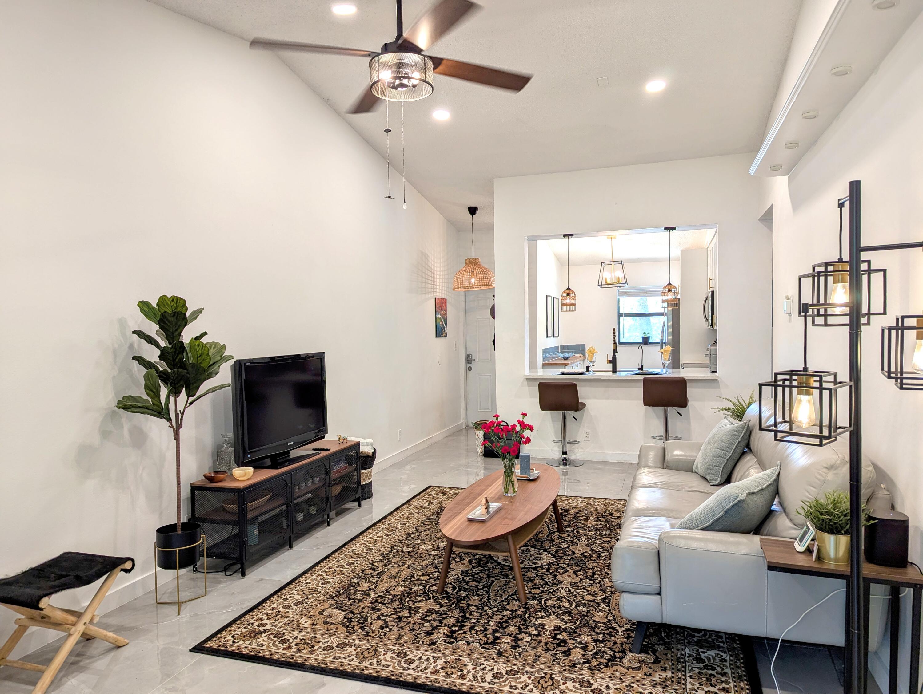 3130 Millwood Terrace, Unit 2160 Boca Raton, FL 33431 - Photo 6 of 34 a living room with furniture and a flat screen tv