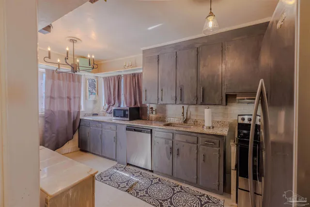 a kitchen with stainless steel appliances granite countertop a sink a stove and a refrigerator