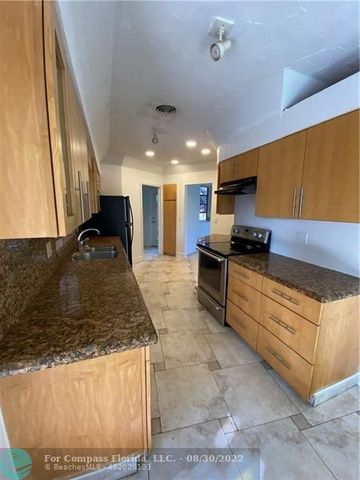 a kitchen with stainless steel appliances granite countertop a sink and a stove