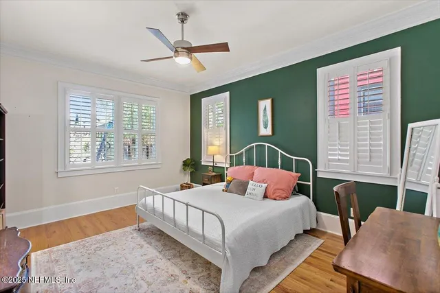 a bedroom with a bed a chandelier and a window