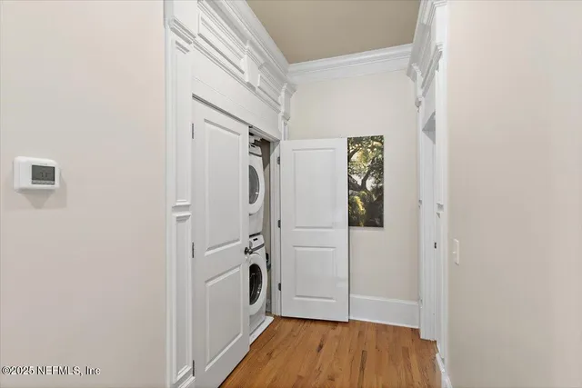 a view of a hallway with wooden floor and cabinets