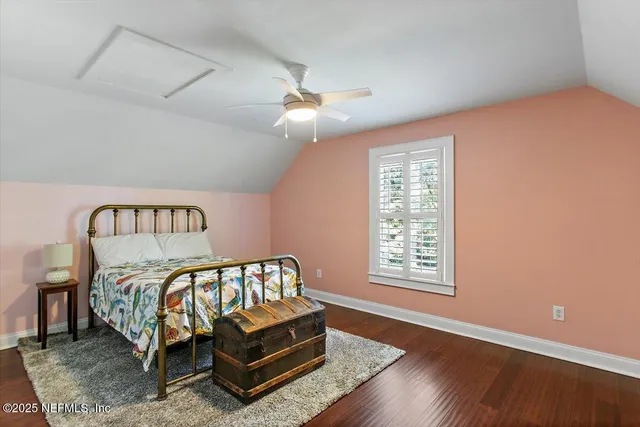 a bedroom with a bed next to a window and a chandelier