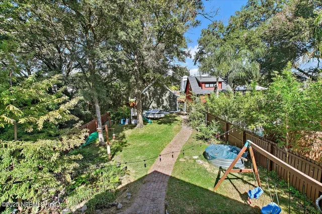 a sign that is sitting in a yard with potted plants