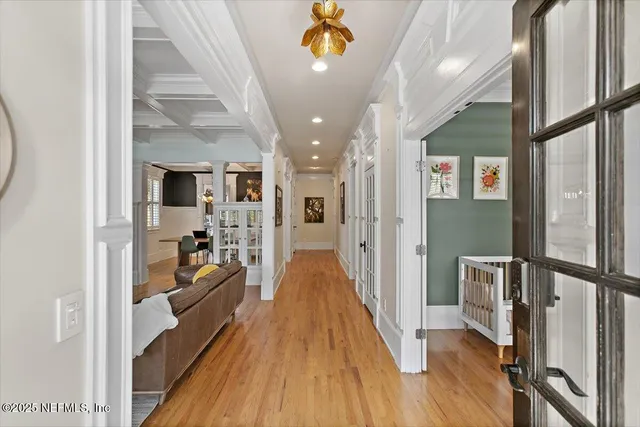 a view of a hallway with wooden floor and staircase