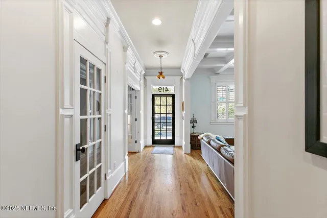 a view of a hallway with wooden floor and staircase