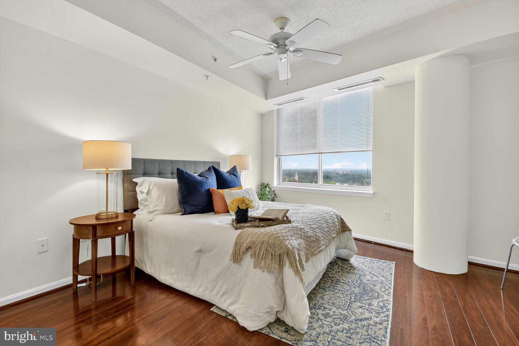 930 Wayne Avenue, Unit 1210 Silver Spring, MD 20910 - Photo 18 of 42 a bedroom with a bed and wooden floor