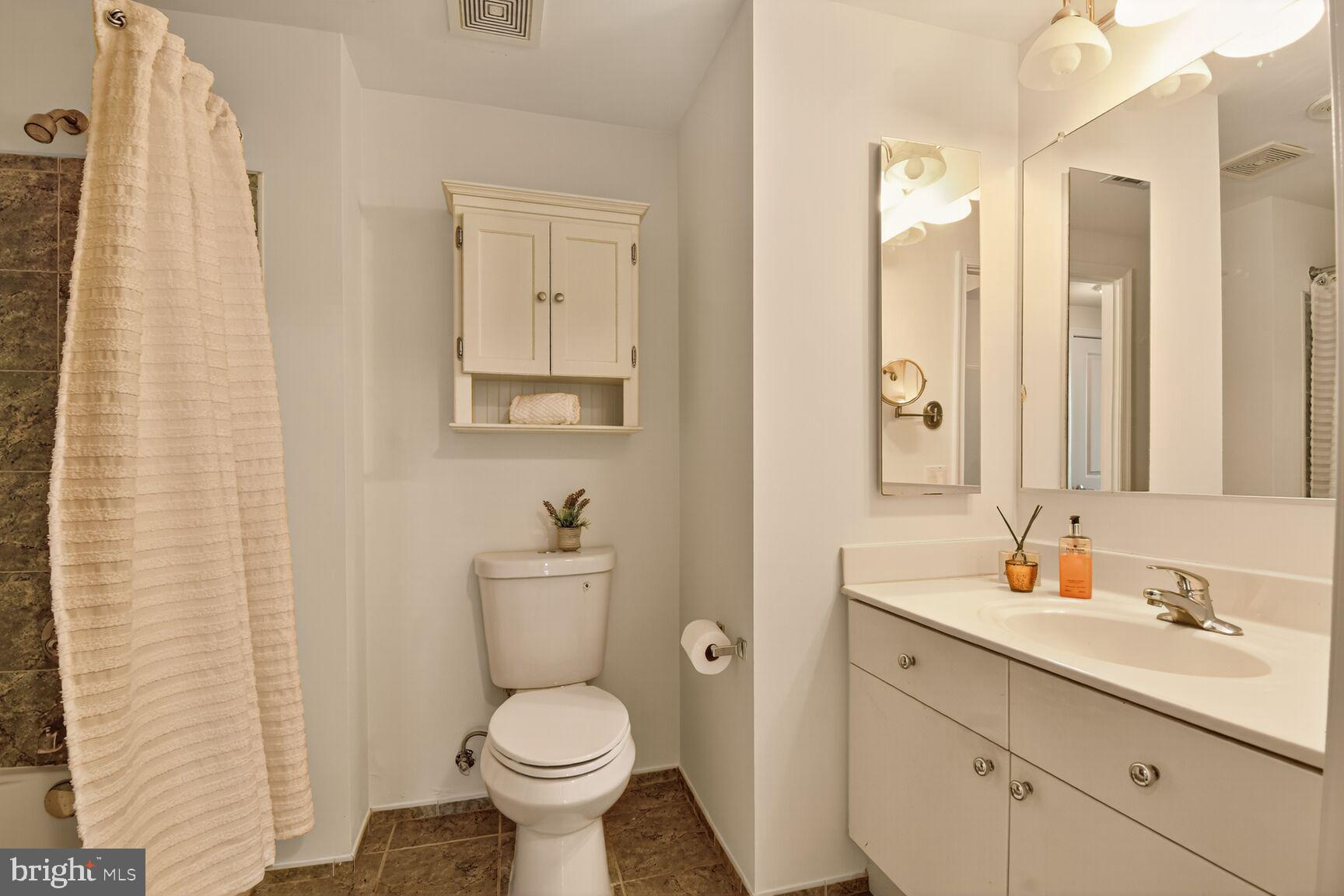 930 Wayne Avenue, Unit 1210 Silver Spring, MD 20910 - Photo 25 of 42 a bathroom with a toilet sink and mirror