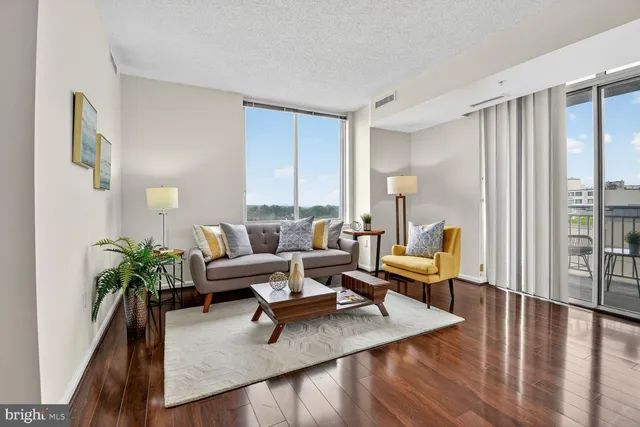 a living room with furniture wooden floor and a potted plant