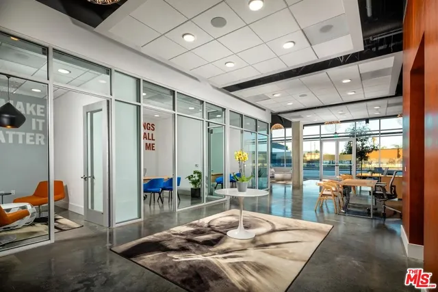 a living room with patio furniture and a floor to ceiling window