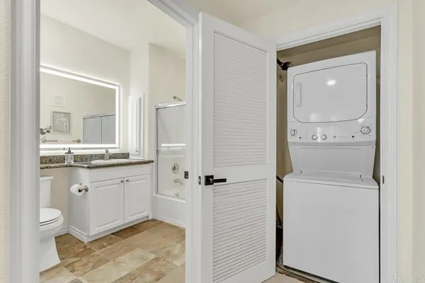 a bathroom with a granite countertop sink mirror and toilet