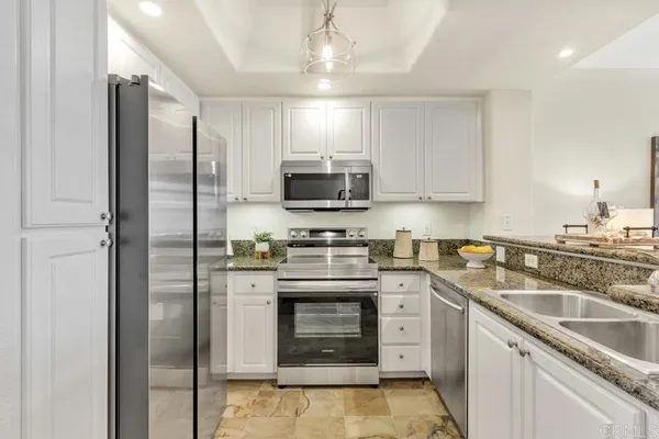 a kitchen with stainless steel appliances granite countertop a stove a refrigerator and a sink