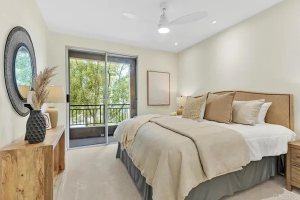 a bedroom with a bed a mirror and a large window