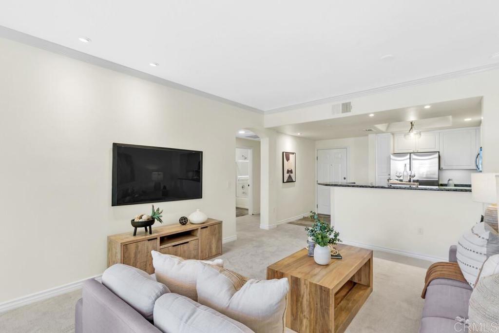 9253 Regents Road, Unit A203 San Diego, CA 92037 - Photo 31 of 38 a living room with furniture and a flat screen tv