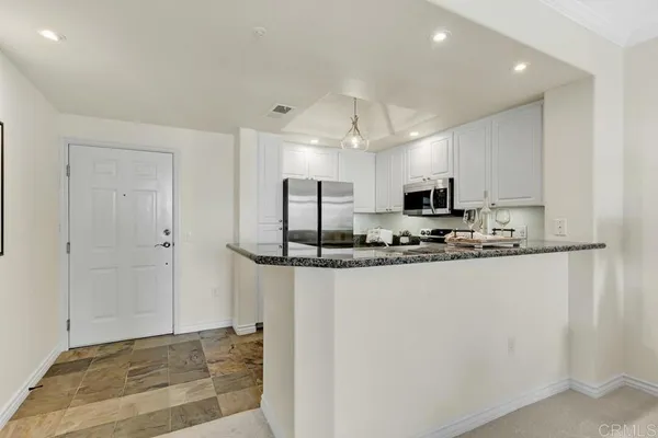 a view of kitchen with stainless steel appliances granite countertop refrigerator sink and stove