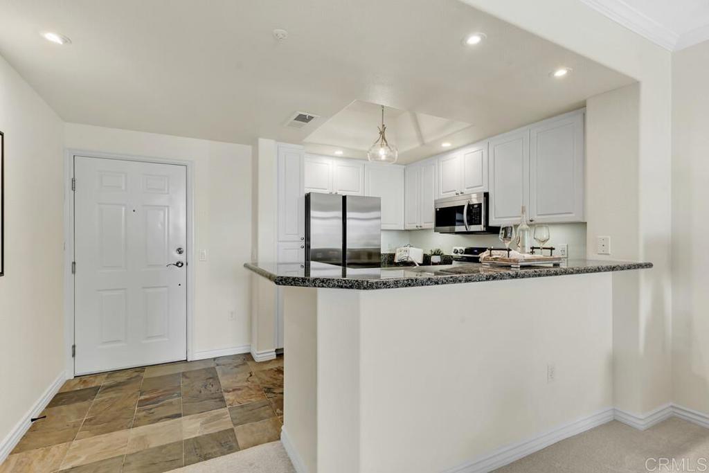 9253 Regents Road, Unit A203 San Diego, CA 92037 - Photo 33 of 38 a view of kitchen with stainless steel appliances granite countertop refrigerator sink and stove