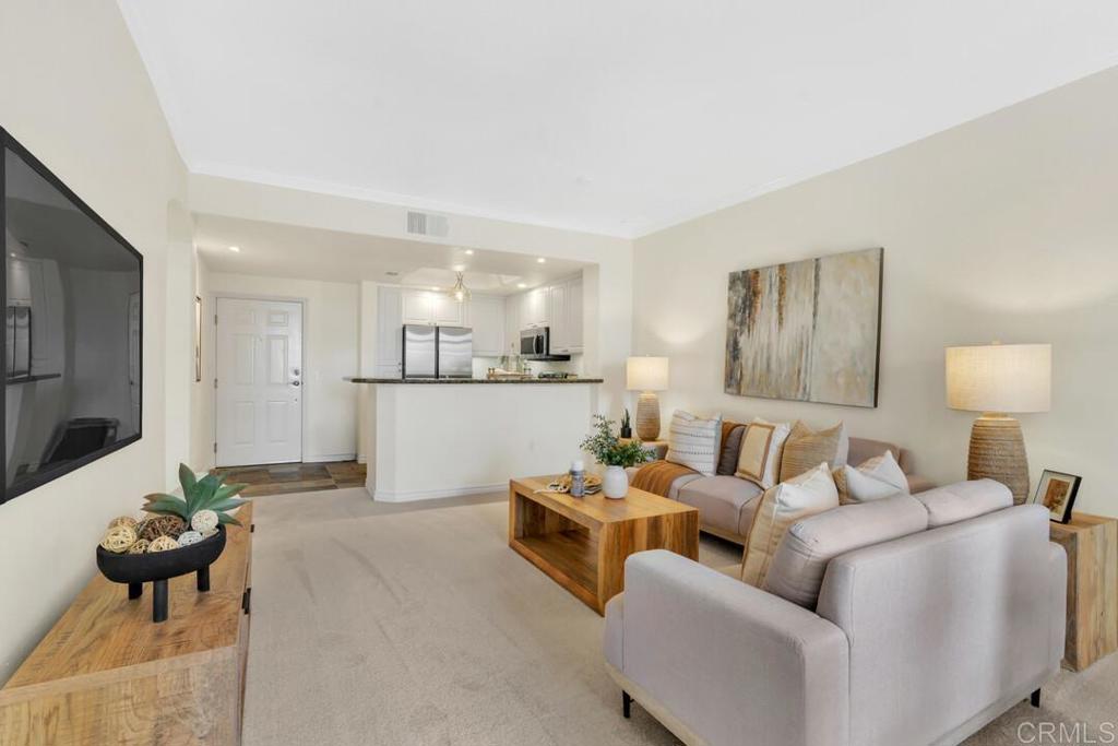 9253 Regents Road, Unit A203 San Diego, CA 92037 - Photo 34 of 38 a living room with furniture white walls and a view of kitchen