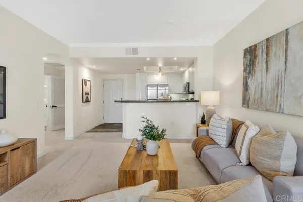a living room with furniture and kitchen view