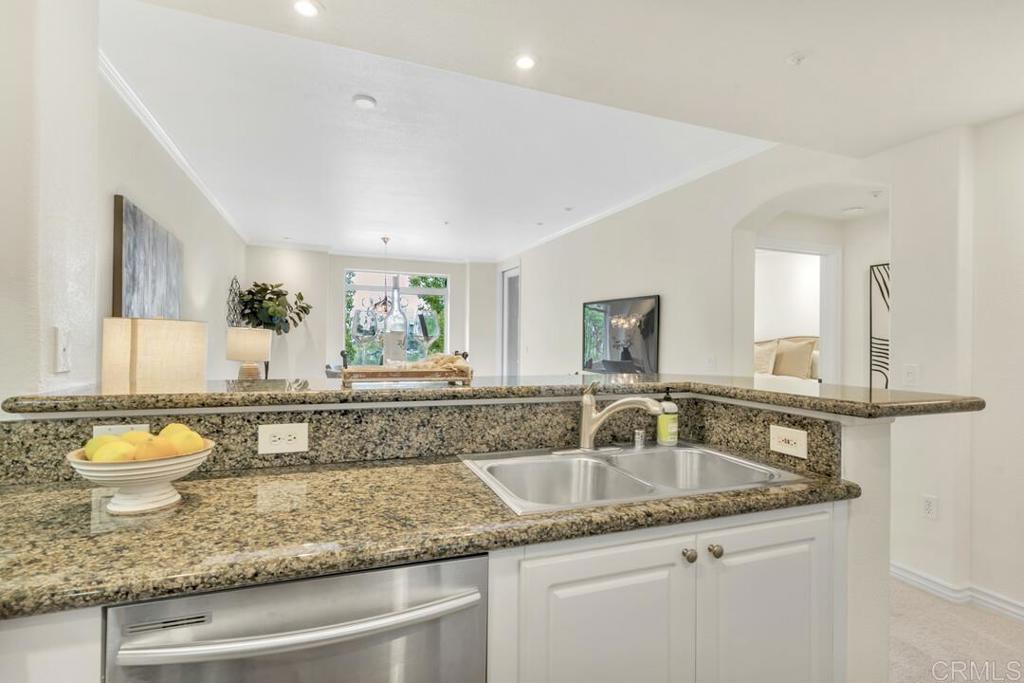 9253 Regents Road, Unit A203 San Diego, CA 92037 - Photo 37 of 38 a bathroom with a granite countertop sink a toilet and a mirror