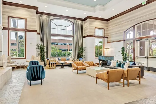 a living room with furniture and floor to ceiling windows