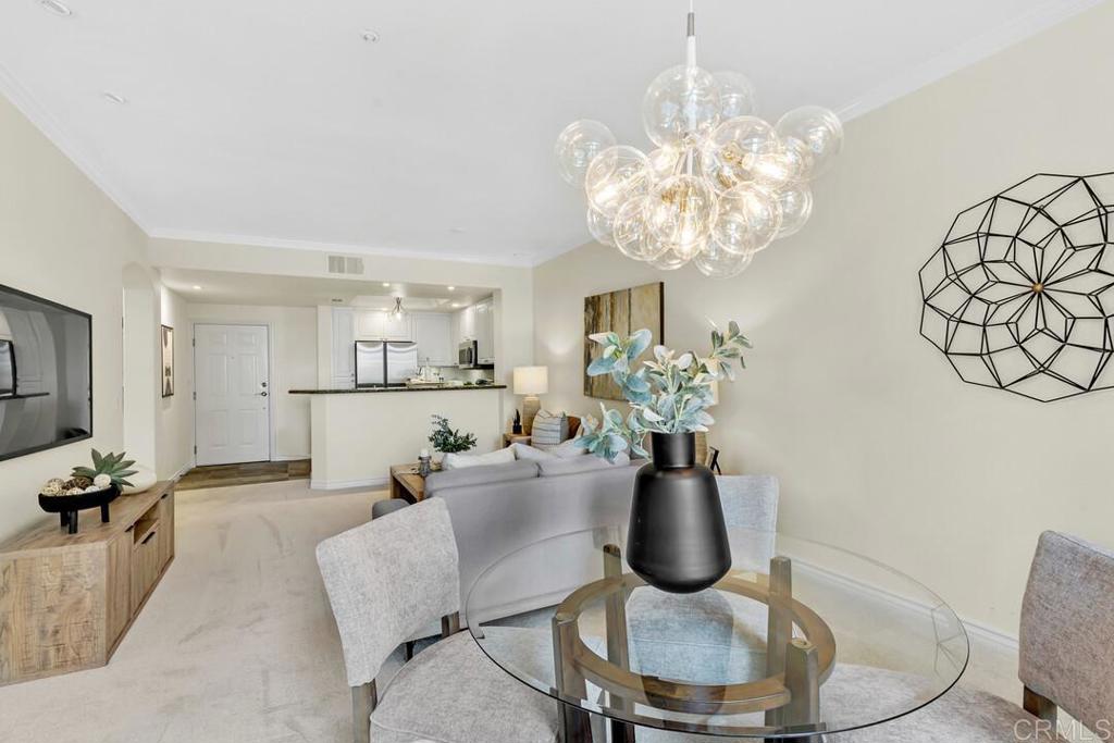 9253 Regents Road, Unit A203 San Diego, CA 92037 - Photo 9 of 38 a dining room with furniture a chandelier and wooden floor