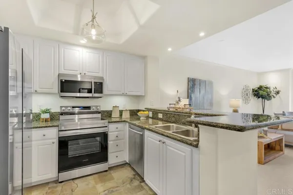 a kitchen with granite countertop a stove sink and microwave