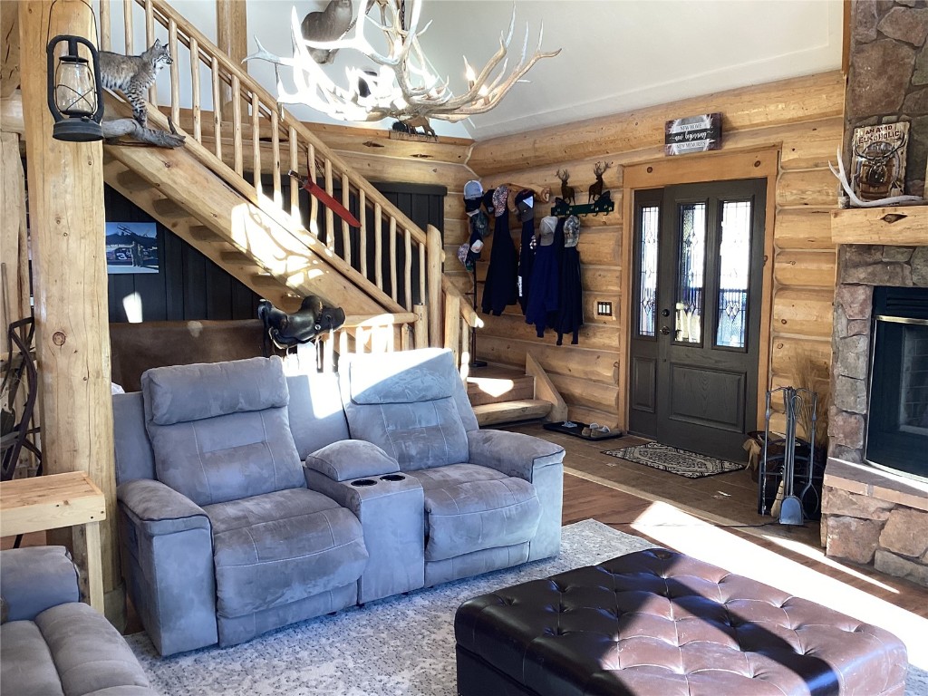 9073 54 7/10 Road Molina, CO 81646 - Photo 13 of 38 Living room featuring wood finished floors, rustic walls, a fireplace, and a chandelier