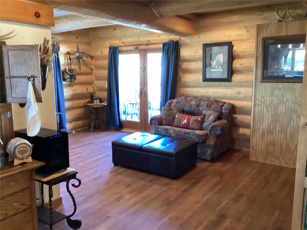 9073 54 7/10 Road Molina, CO 81646 - Photo 18 of 38 Living room featuring wood finished floors, beam ceiling, and rustic walls