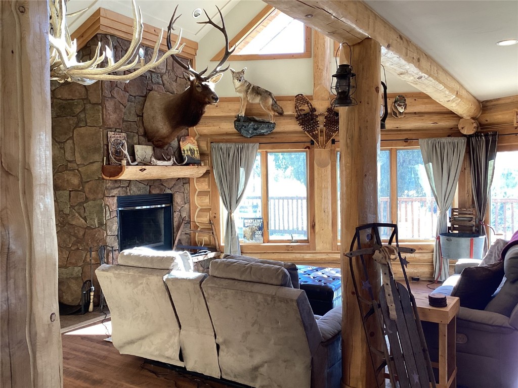 9073 54 7/10 Road Molina, CO 81646 - Photo 10 of 38 Living area featuring a fireplace, wood finished floors, rustic walls, plenty of natural light, and lofted ceiling