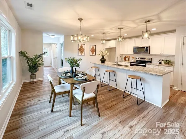 a kitchen with stainless steel appliances kitchen island granite countertop a stove a sink and a refrigerator