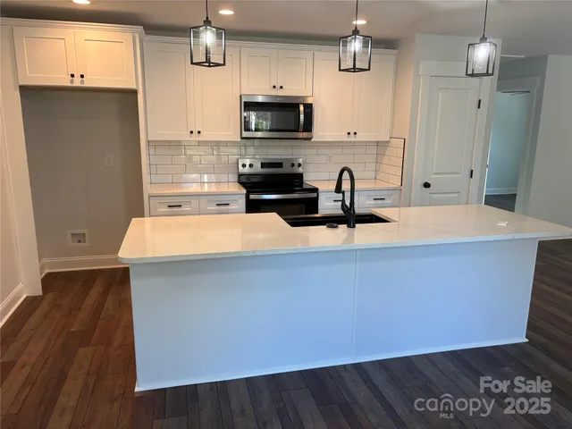 a kitchen with a sink a microwave a stove and refrigerator