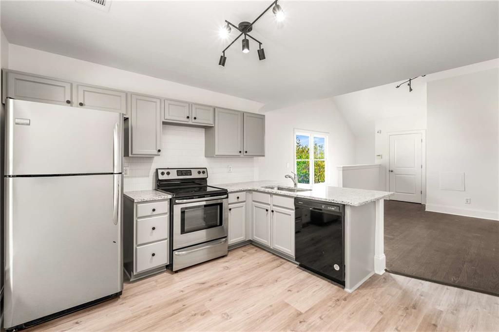 94 Lucy Street Southeast, Unit A Atlanta, GA 30312 - Photo 14 of 25 a kitchen with granite countertop a refrigerator stove top oven and sink