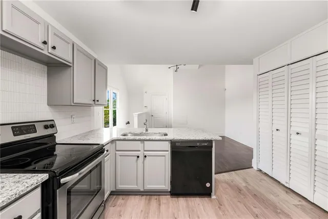 a kitchen with a sink a stove and cabinets