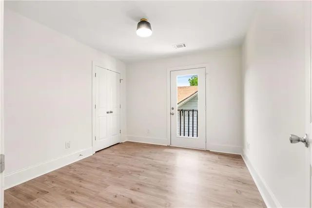 an empty room with wooden floor and window