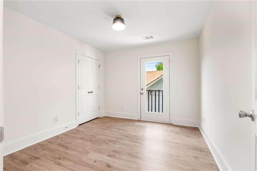 94 Lucy Street Southeast, Unit A Atlanta, GA 30312 - Photo 20 of 25 an empty room with wooden floor and window