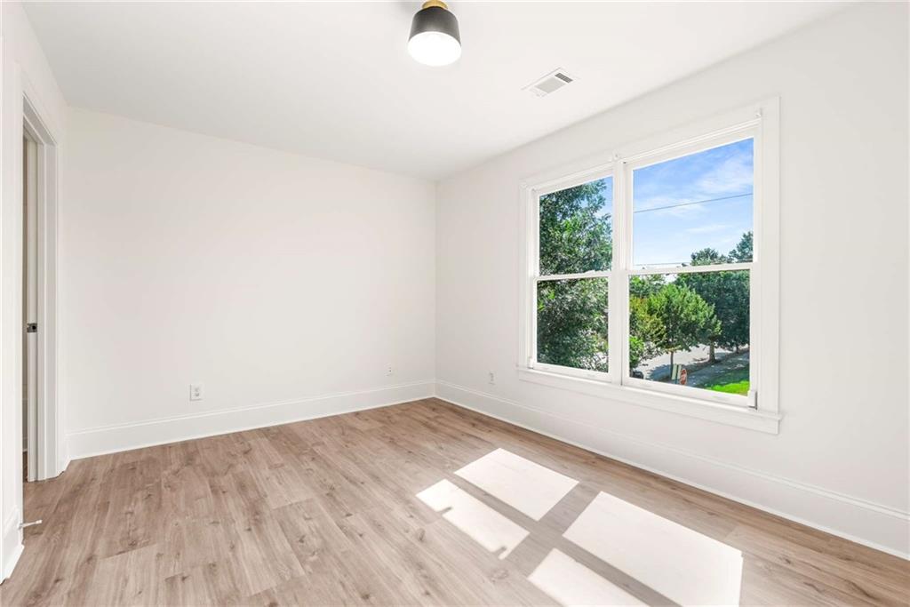 94 Lucy Street Southeast, Unit A Atlanta, GA 30312 - Photo 21 of 25 an empty room with wooden floor and windows