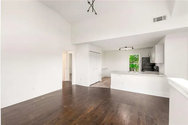 a view of a big room with wooden floor and a window