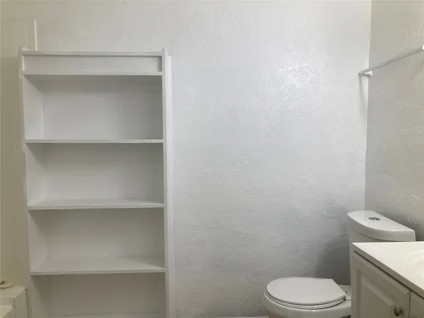 a white toilet sitting next to a shower