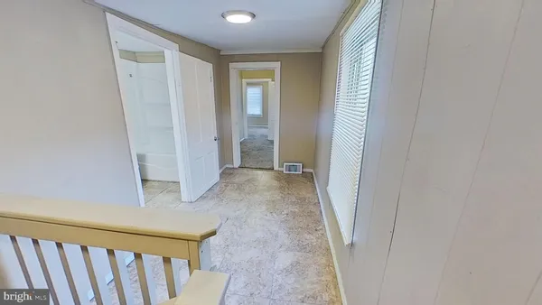 a view of a hallway with wooden floor and entryway