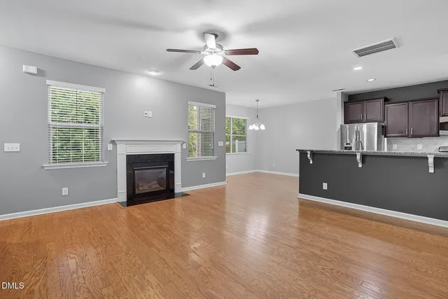 a view of a kitchen with a stove cabinets a ceiling fan and wooden floor