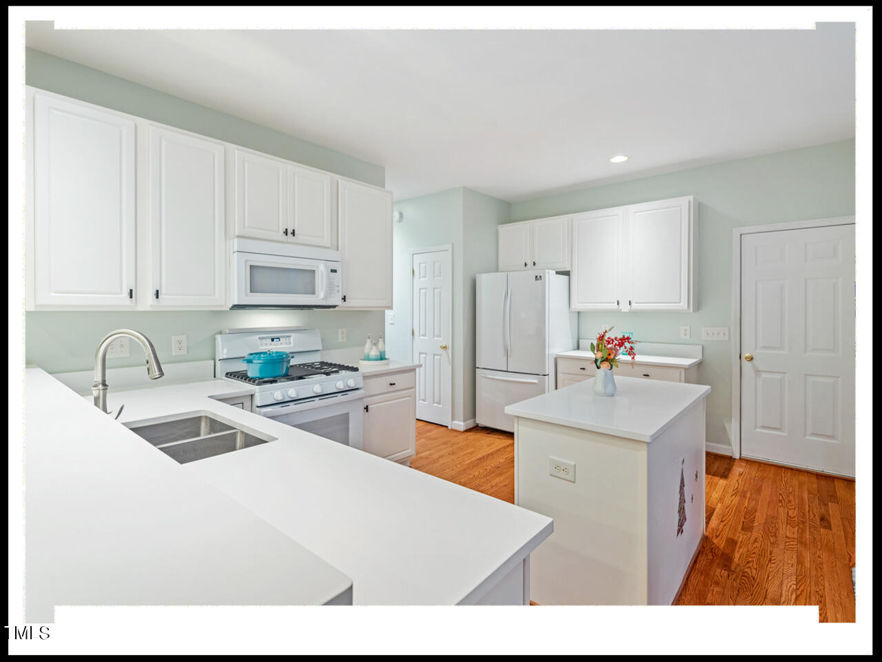 8214 Morrell Lane Durham, NC 27713 - Photo 12 of 48 a kitchen with stainless steel appliances granite countertop a sink refrigerator and white cabinets with wooden floor