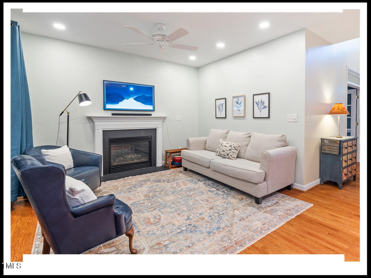 8214 Morrell Lane Durham, NC 27713 - Photo 10 of 48 a living room with furniture a flat screen tv and a fireplace