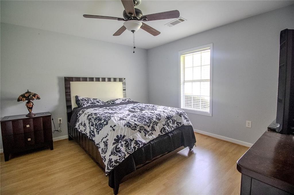 4184 Red Laurel Way Southwest Snellville, GA 30039 - Photo 22 of 35 a bedroom with a bed and wooden floor