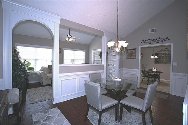 a dining room with furniture a chandelier and wooden floor