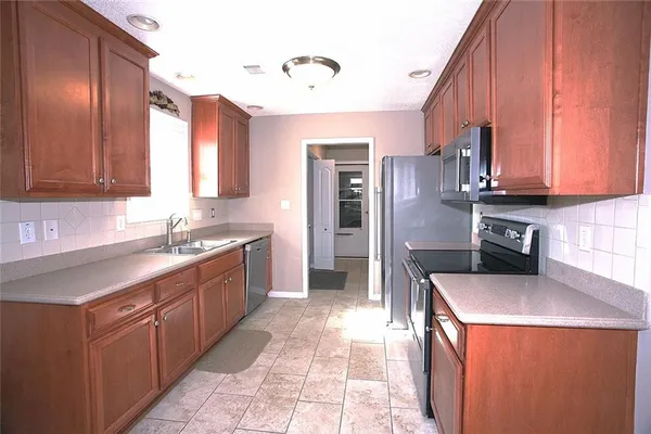 a kitchen with a sink stove and refrigerator
