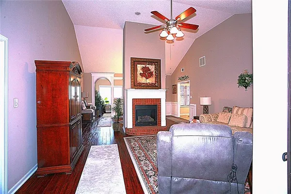 a living room with furniture a fireplace and a chandelier